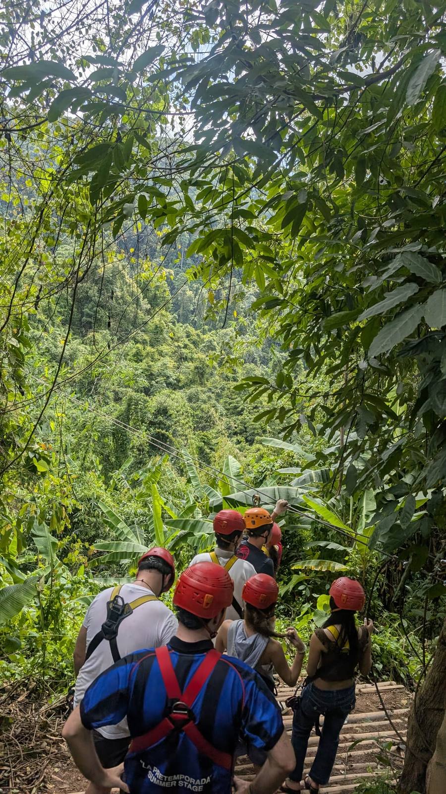 Grupo con casco y arnés en un recorrido de tirolinas por la selva de Chiang Mai