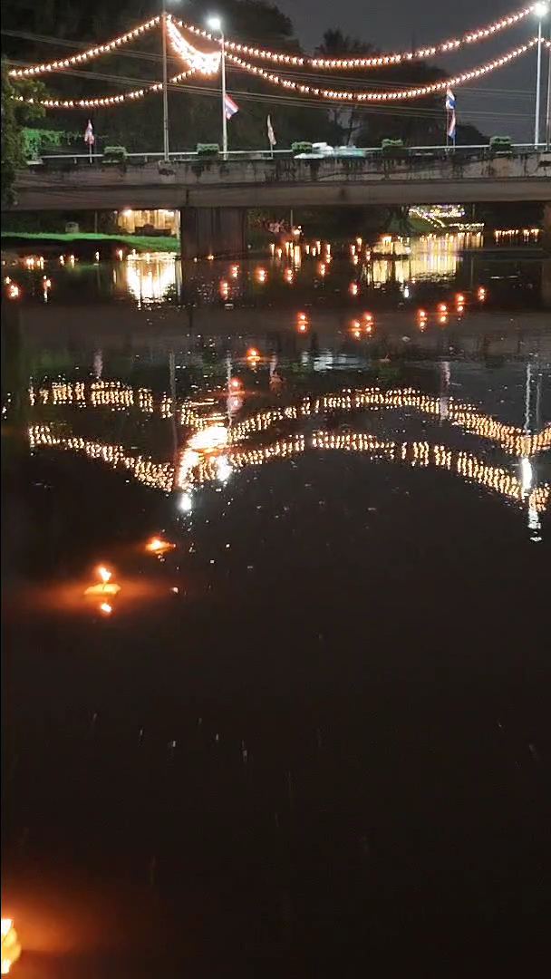 Krathongs flotando de noche sobre un río en Tailandia durante la celebración de Loy Krathong