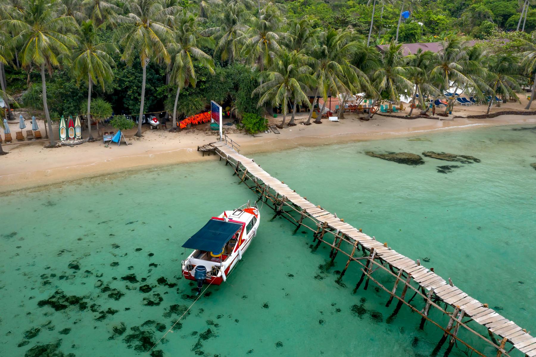 Embarcadero de madera junto a un resort tropical en Tailandia